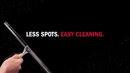 Hand holding a squeegee with text 'LESS SPOTS. EASY CLEANING.' on a black background